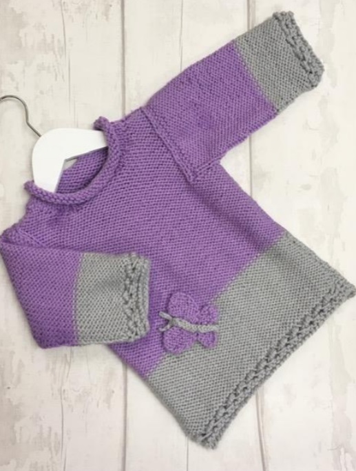 Free knit pattern for a girls sweater with butterfly